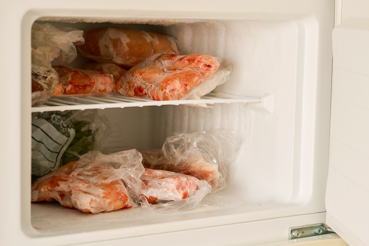 Vacuum sealed bags of frozen meat in an open freezer.