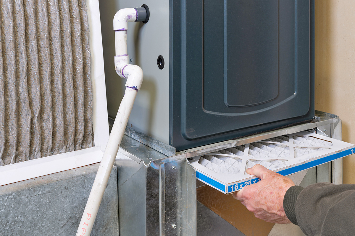 Anonymous person replacing their furnace's filter.