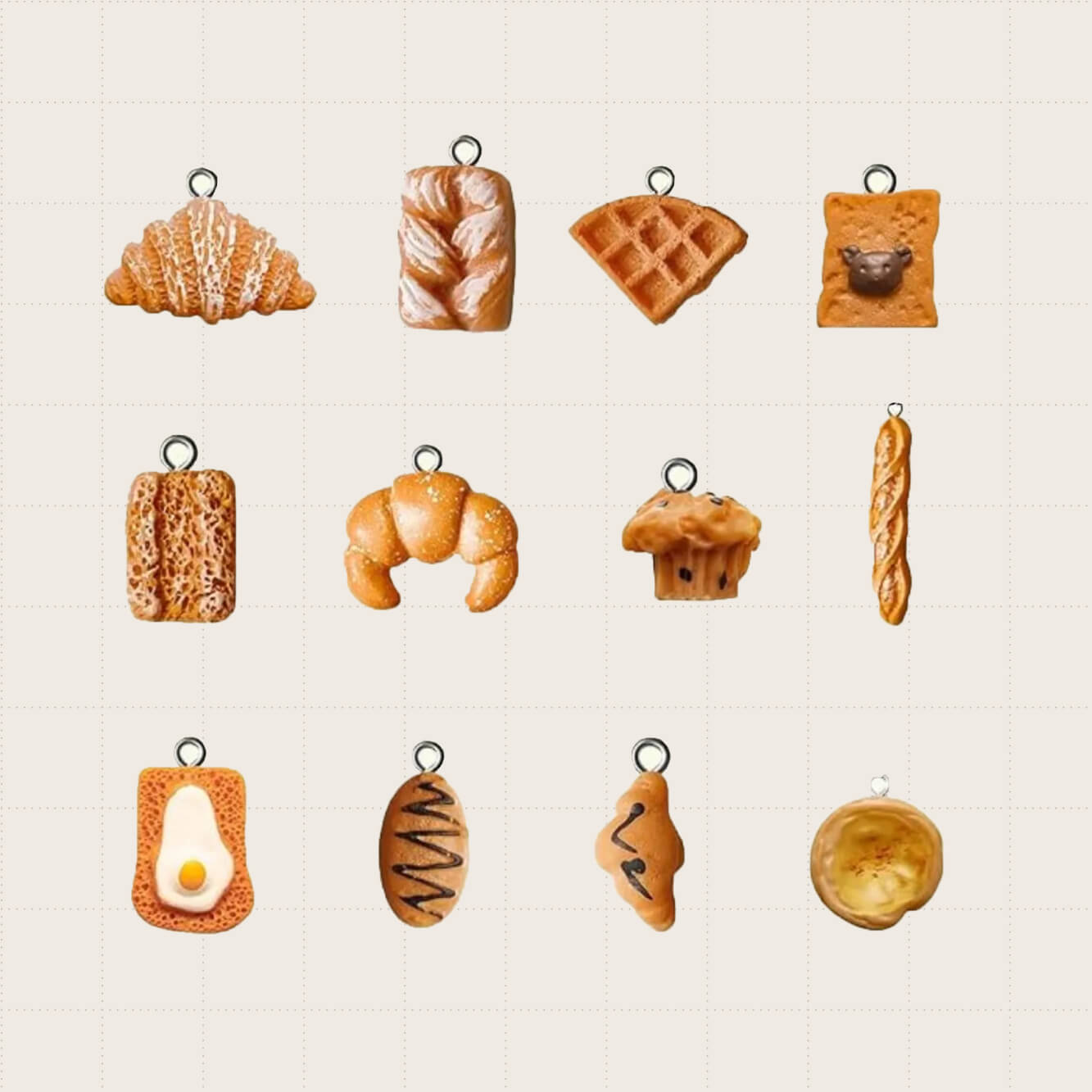 Twelve pastry-themed wine glass charms in shapes like croissant, baguette, pie, and muffin.